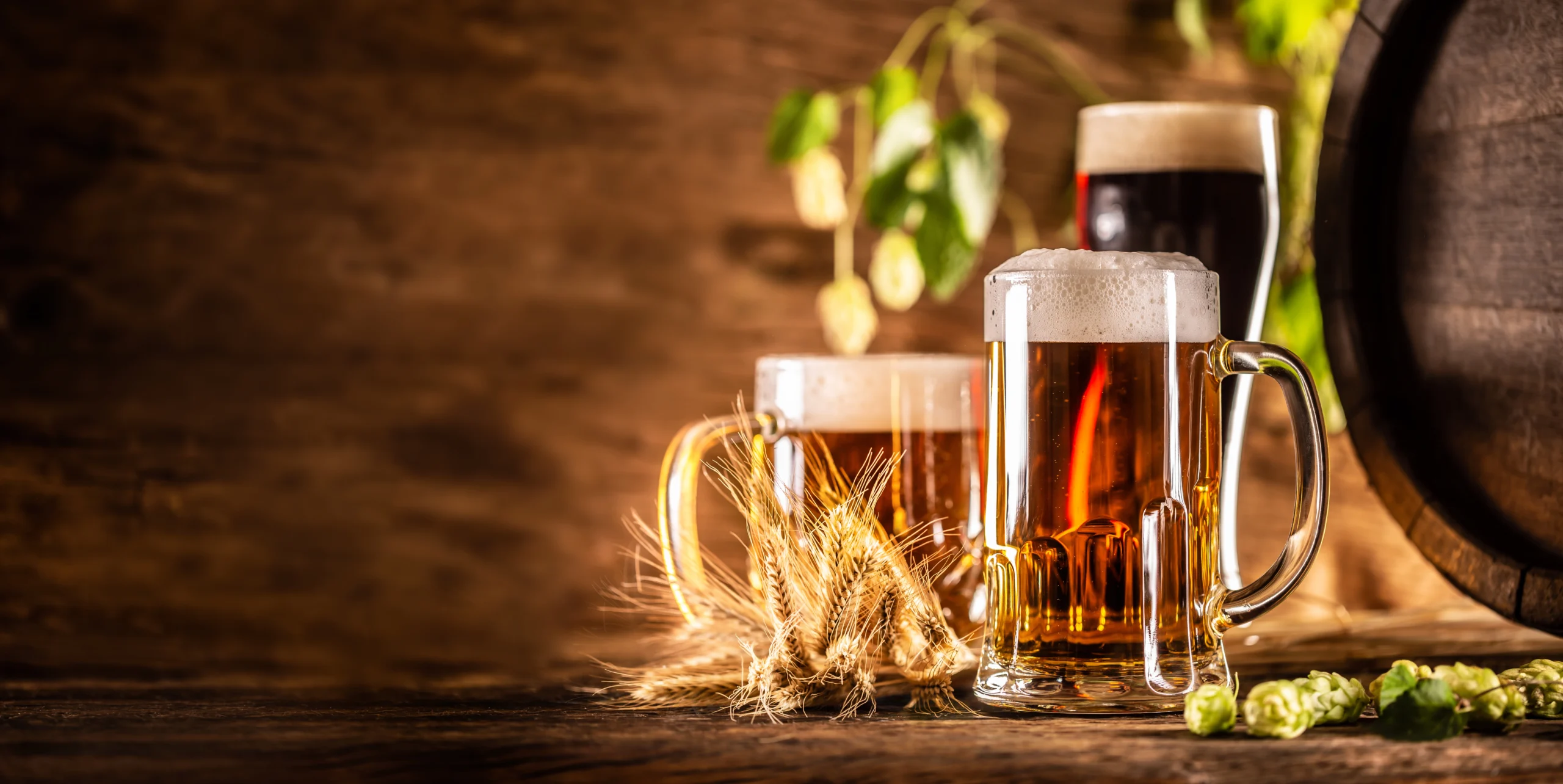 three-glasses-with-draft-beer-front-wooden-barrel-decoration-barley-ears-fresh-hops